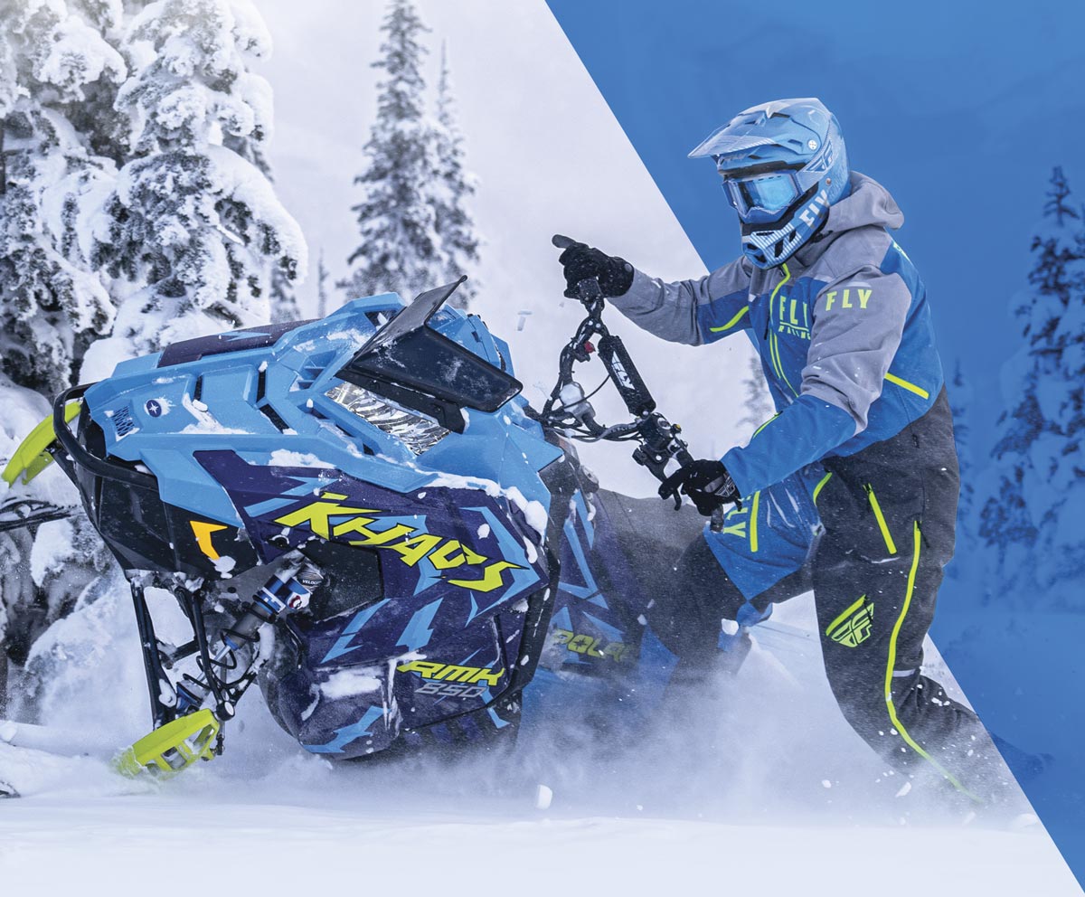 Rider in Fly Racing Suit snowmobiling on mountain