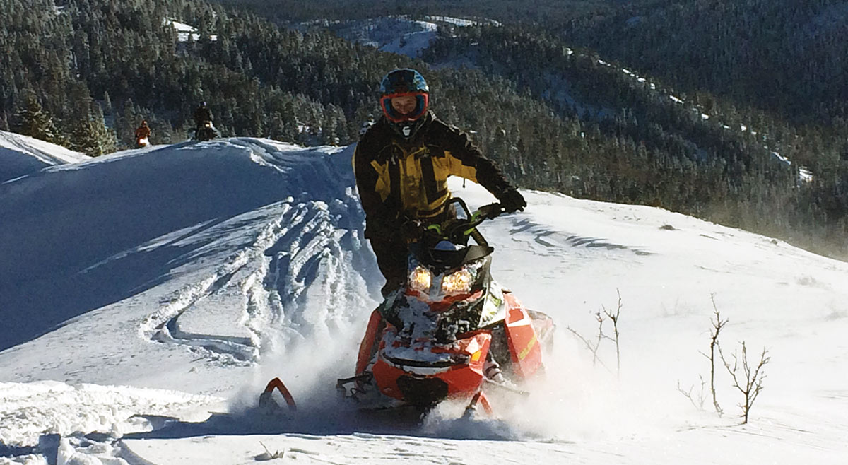 a man riding a ridge in his snow mobile
