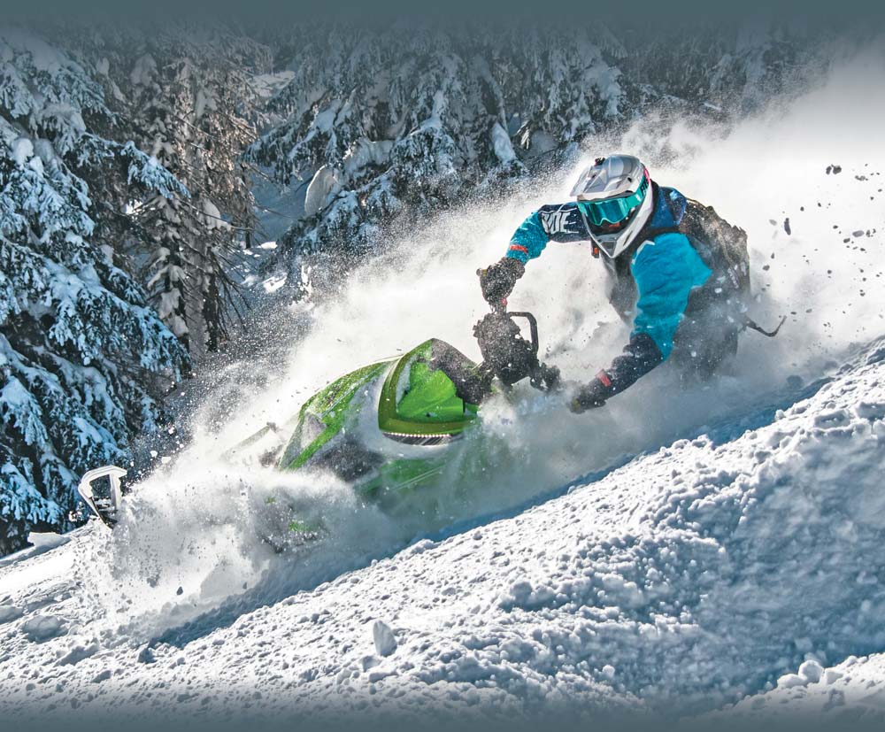 Rider snowmobiling on mountain