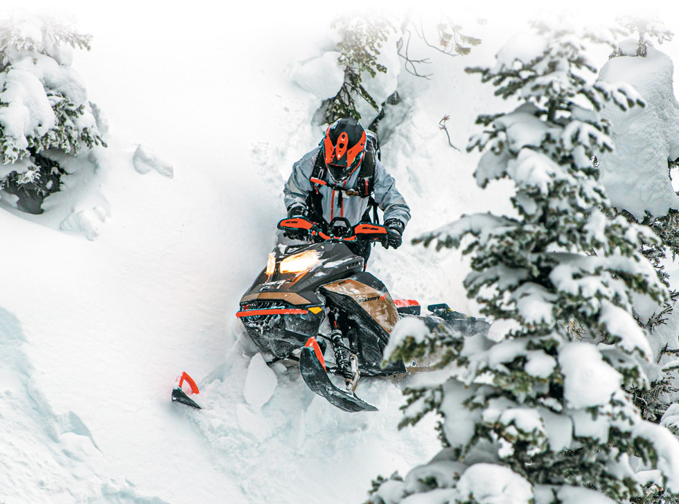 man riding down a mountain on a snowmobile